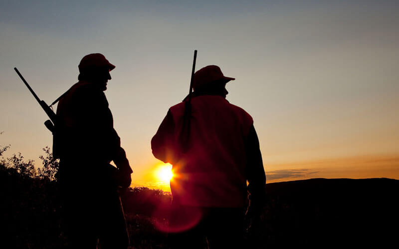 two hunters watching the sunset