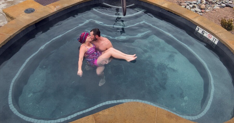 couple kissing in heartshaped hot springs pool