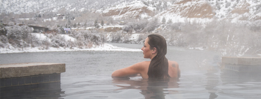 Woman soaking at Iron Mountain Hot Springs in the snow