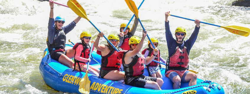 group rafting on the colorado river with paddles in the air